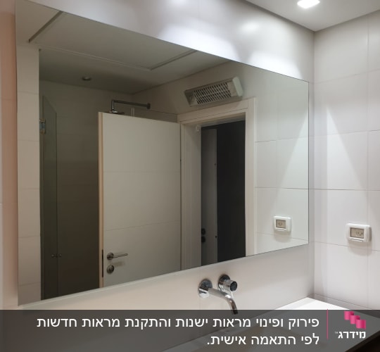 מראה גדולה מעל כיור בחדר אמבטיה מואר